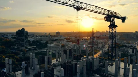 High-rise building in progress with machinery at sunset. Modern Construction Video stock 116879618