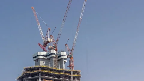 High-rise building under construction. The site with cranes against blue sky Stock Footage 189782858