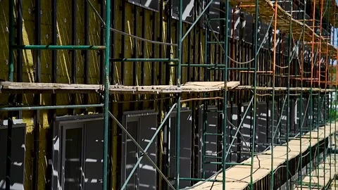 High-rise building under construction with scaffolding Stock Footage 310052706