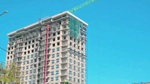 A high-rise building is under construction with a crane visible in operation. Stock Footage 339090759