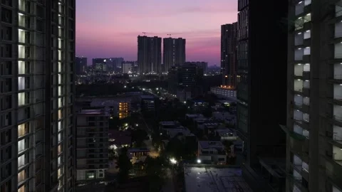 High-rise building with under construction buildings, villas and twilight at Vídeos de archivo 340027402