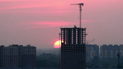 High rise building under construction with tower crane at sunset Stock Footage 346648118