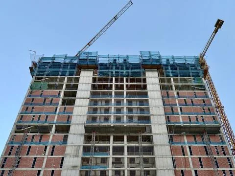 High rise building under construction with scaffolding, safety nets, tower .. 스톡 사진