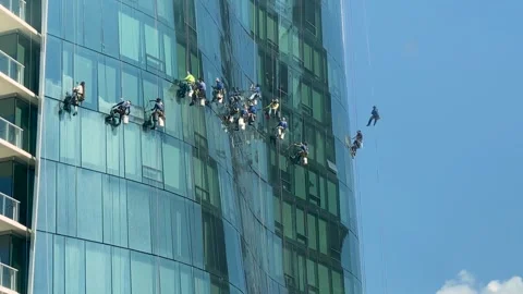 High-rise condominium window washers working outside a glass-faced tower. Stock Footage 291461130