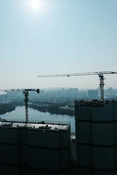 High rise construction cranes over river city skyline Stock Photos