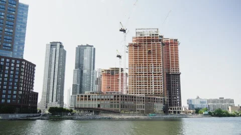 High rise construction riverfront with three construction cranes in Manhatta Stock Footage 243811409