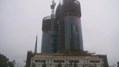 High rise construction site on a cloudy day - lifts up and down Stock Footage 93375574