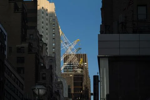 High-rise construction tower crane against the backdrop of a beautiful blue sky Stock Photos