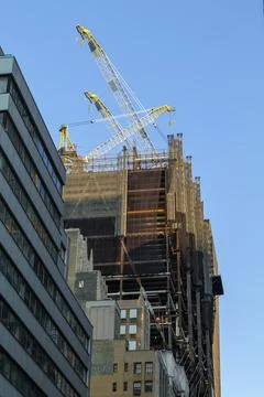 High-rise construction tower crane against the backdrop of a beautiful blue sky Stock Photos