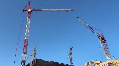 A high-rise crane against a blue sky during the construction of a building Stock Footage 336941580