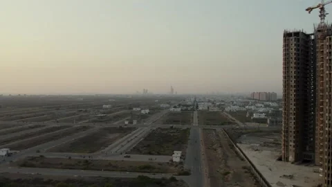 High-rise under construction beside undeveloped urban plots Stock Footage 261501061