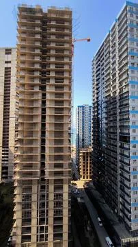 High Rise Under Construction Next to Finished Residential Building. Stock Photos