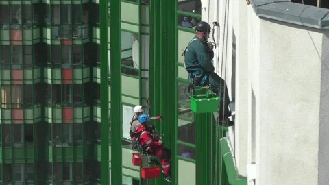 High-rise workers cleaning the windows of a tall building Stock Footage 244794056
