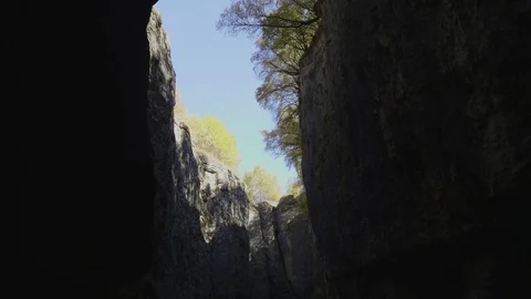 High rocks of dark stone gorge with blue sky strip and trees Stock Footage 108167658