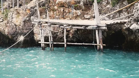 High rocks in the sea with old small wooden pier. slow motion. 1920x1080 Video stock 87897067