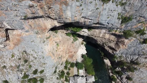 High rocks under which the river flows, shot by drone. The source of the river Stock Footage 324684516