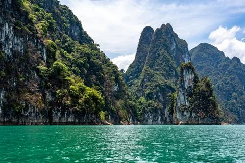 High rocky cliff trees covered in the lake Stock Photos