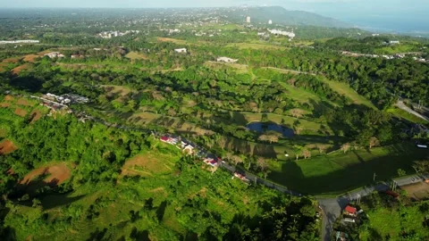 High rotating aerial showcasing mountains and patterned farm plots beneath Stock Footage 331340727