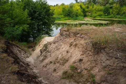 High sandy ravine falls down into the river Stock Photos