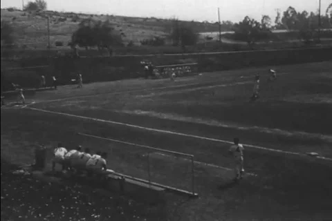 A high school baseball team plays to a very excited crowd in the 1940s Stock Footage 99843938