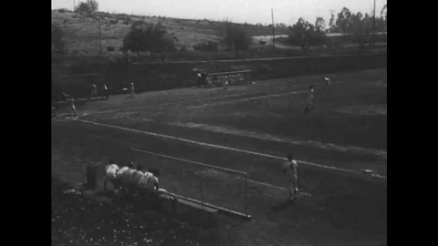 A high school baseball team plays to a very excited crowd in the 1940s Stock Footage 115359796