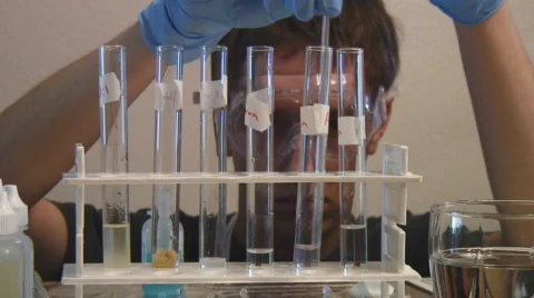 High school chemistry student performs test tube experiement Stock Footage 107785