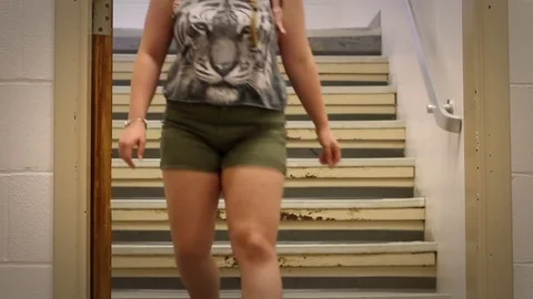 High school female walks down the steps at public high school Stock Footage