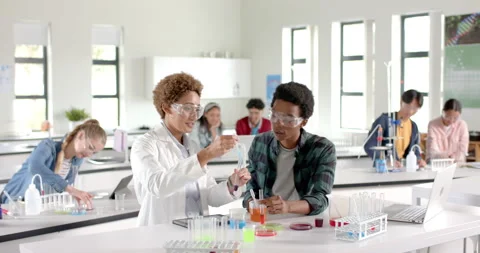 In high school laboratory, students conducting experiment with test tubes and Stock Footage 299885148