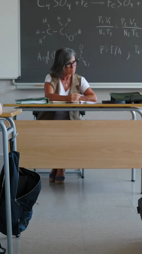 High school student giving cheat sheet to classmate during examination in class Stock Footage 312198156