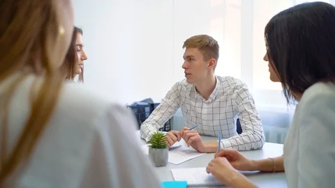 High school student group discussing and solving project assignment at table Stock Footage 97519155