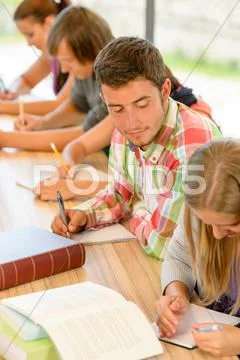 High-school student peeking at his colleague quiz Stock Photos