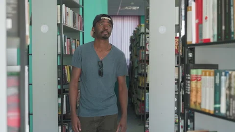 High School Student Searching For Book On Library Shelf Stock Footage 318712907