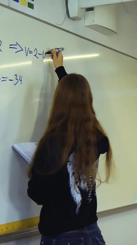 High school student solving a math problem on a whiteboard Stock Footage 347064706