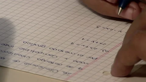 High School Student Writing on Graph Paper during a Math Lesson. Close Up. Stock Footage 224779325