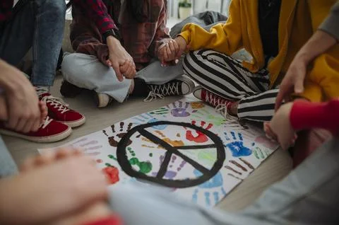 High school students holding hands around peace symbol during group activity. Stock Photos