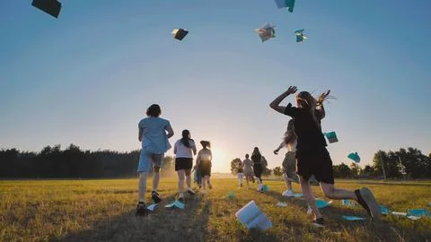 High school students joyfully marking the end of school by running through a Stock Photos