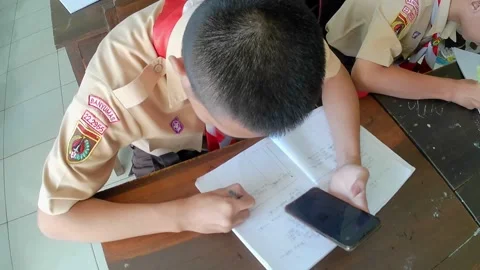 High school students in Scout uniforms are doing a writing assignment Stock Footage 242818784