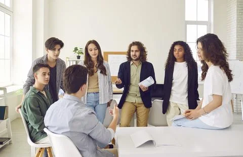 High school students sitting in a circle in the classroom and talking with their Foto stock