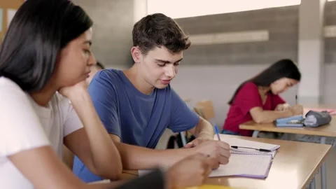 High school students sitting at table studying together in classroom. Stock Footage 242881132