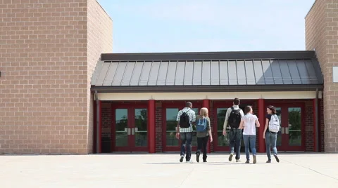 High school students walking into school, one student running behind Stock Footage 60923655