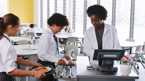 High School Students Wearing Uniform Paying For Meal In Cafeteria Stock Footage 99807012