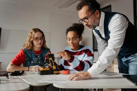 High school students working on robotics project with their teacher. Stock Photos