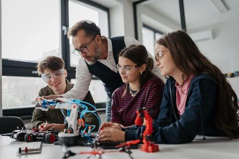 High school students working on robotics project with their teacher. Stock Photos