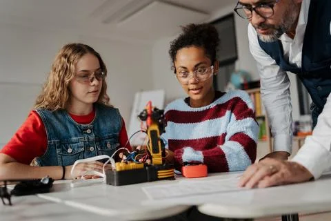 High school students working on robotics project with their teacher. Stock Photos