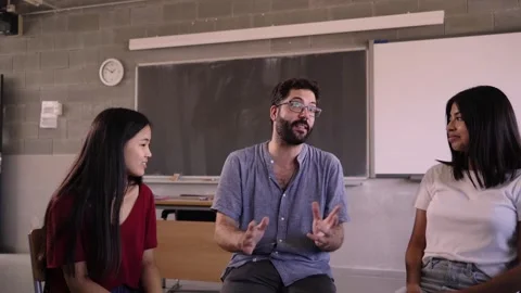 High school teacher discusses concepts from course syllabus with students Stock Footage 254125495