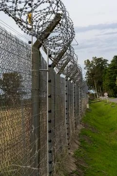 High-security fence with razor wire and metal mesh Stock Photos
