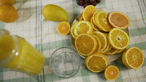High, slow motion shot of pitcher pouring juice into glass near orange slices Stock Footage 341253567