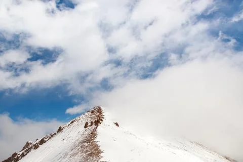 High snowy mountain range with blue sky background with copy space Stock Photos