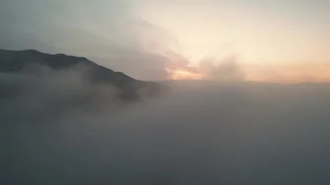 High snowy mountains covered with dense haze, blue sky with clouds at dawn. Stock Footage 253872387