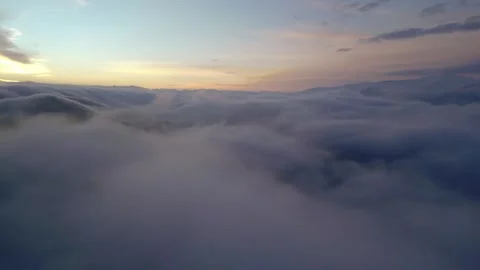 High snowy mountains covered with dense haze, blue sky with clouds at dawn. Stock Footage 253873497